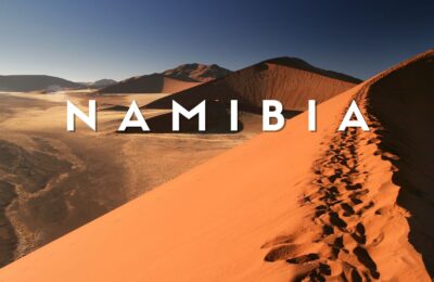Deserto del Namib al tramonto con dune rosse illuminate dalla luce dorata del sole in Namibia