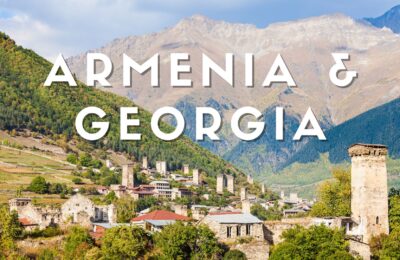 Veduta panoramica di Mestia nella regione della Svaneti in Georgia con le caratteristiche torri difensive medievali e le montagne del Caucaso sullo sfondo.