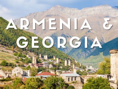 Veduta panoramica di Mestia nella regione della Svaneti in Georgia con le caratteristiche torri difensive medievali e le montagne del Caucaso sullo sfondo.