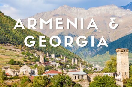 Veduta panoramica di Mestia nella regione della Svaneti in Georgia con le caratteristiche torri difensive medievali e le montagne del Caucaso sullo sfondo.