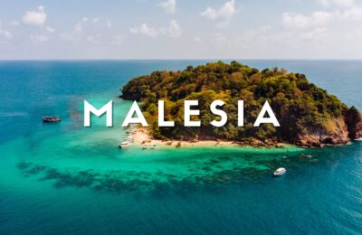 Veduta aerea dell'Isola di Pom Pom nel Borneo malese: spiaggia bianca, barriera corallina e Water Villa sul mare cristallino del Sabah.