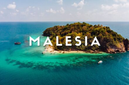 Veduta aerea dell'Isola di Pom Pom nel Borneo malese: spiaggia bianca, barriera corallina e Water Villa sul mare cristallino del Sabah.