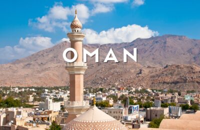 Forte di Nizwa e palmeti con montagne sullo sfondo nella storica città di Nizwa, Oman