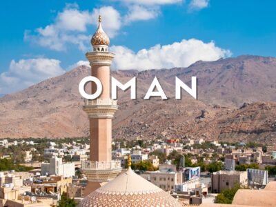 Forte di Nizwa e palmeti con montagne sullo sfondo nella storica città di Nizwa, Oman