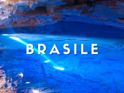 Grotta sotterranea con lago d'acqua cristallina dai riflessi blu intenso e formazioni rocciose nella Chapada Diamantina, Brasile.
