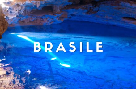 Grotta sotterranea con lago d'acqua cristallina dai riflessi blu intenso e formazioni rocciose nella Chapada Diamantina, Brasile.