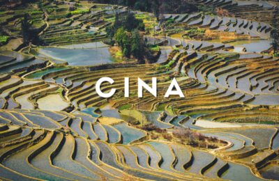 Panorama all'alba delle terrazze di riso di Yuanyang allagate nello Yunnan, Patrimonio UNESCO, con riflessi di luce solare e montagne sullo sfondo.